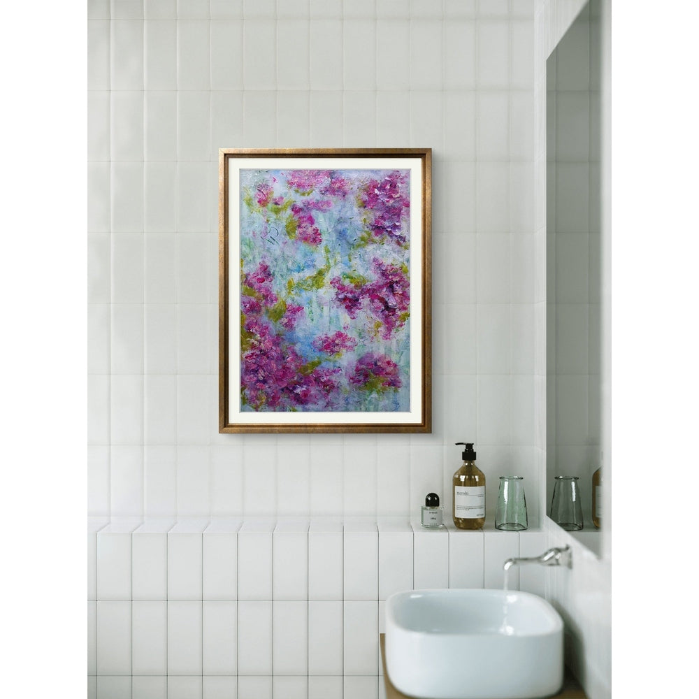 A vibrant mixed media artwork featuring abstract floral elements. The composition is dominated by soft hues of pink and magenta, representing clusters of flowers, interspersed with shades of green suggesting foliage. The background is a dreamy blend of pastel blues and whites, creating a soft, airy atmosphere. The texture is rich and layered, with visible brushstrokes and dynamic patterns that give the piece depth and movement.

