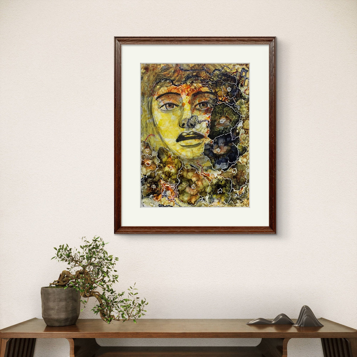 “Mixed-media portrait titled The Interwoven Connection showing a face merging with abstract botanical and textured forms, outlined with white organic lines in earthy brown, green, yellow, and black, framed view.”